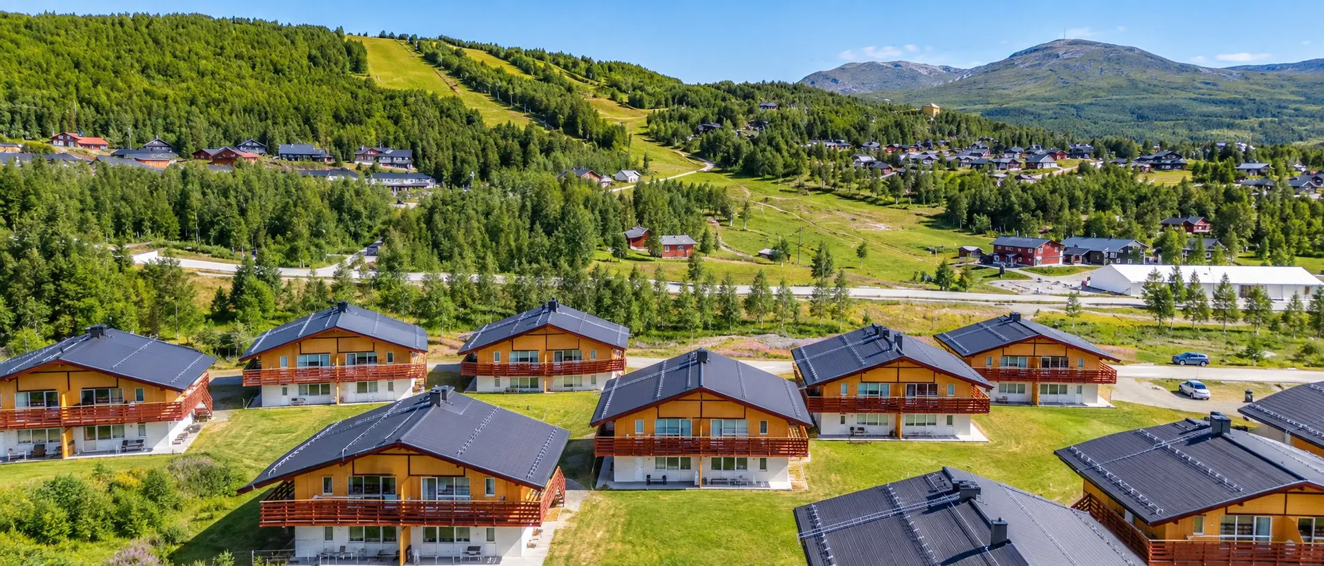 Brf Storfjället's buildings seen from the air, with the mountain behind
